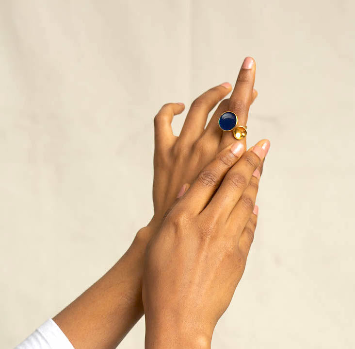hands of a model wearing a gold zivanora bypass ring with her hands to the sky